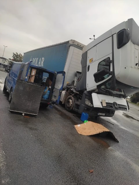 Niebieski mobilny serwis pomagający białej ciężarówce na poboczu drogi.