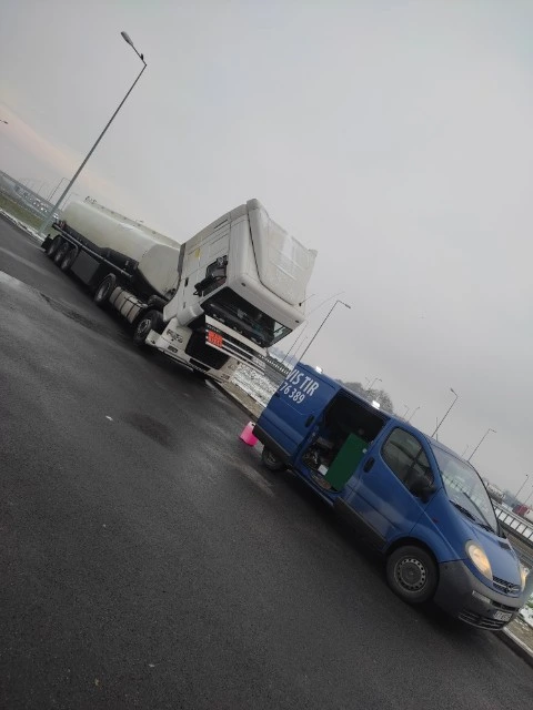 Wóz serwisowy zapewniający pomoc drogową ciężarówce w świetle dziennym.